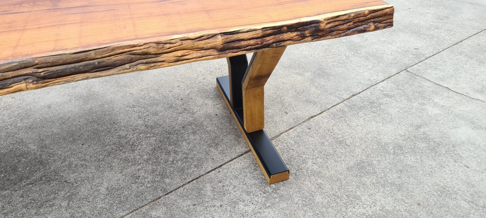 Boomstamtafel van iroko met een designonderstel van hout en staal